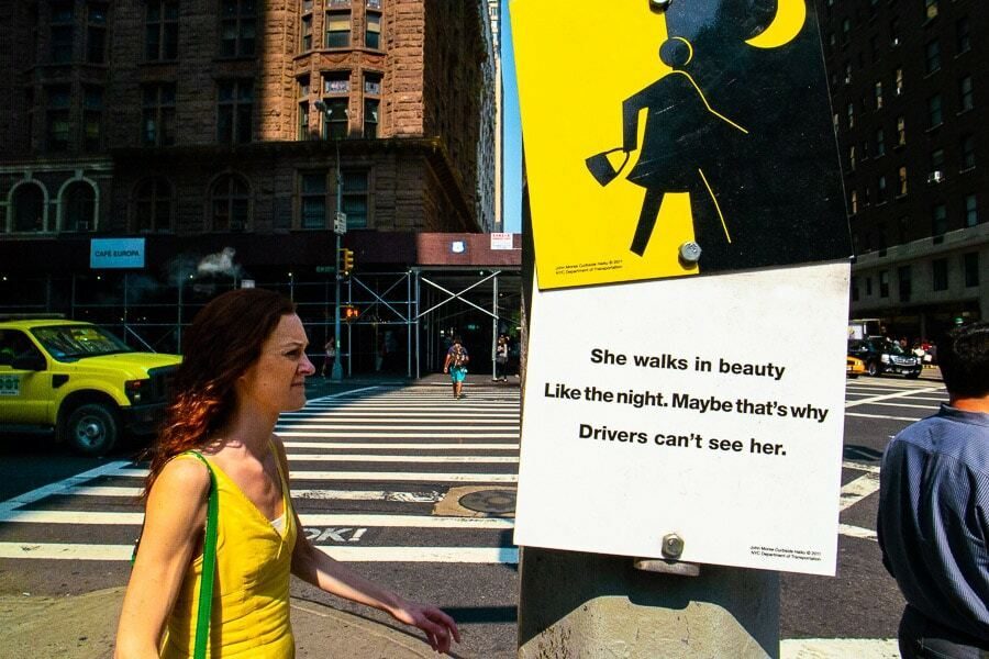 New York street corner with a woman in a yellow dress, a yellow taxi and a yellow sign repeating the same color across the frame