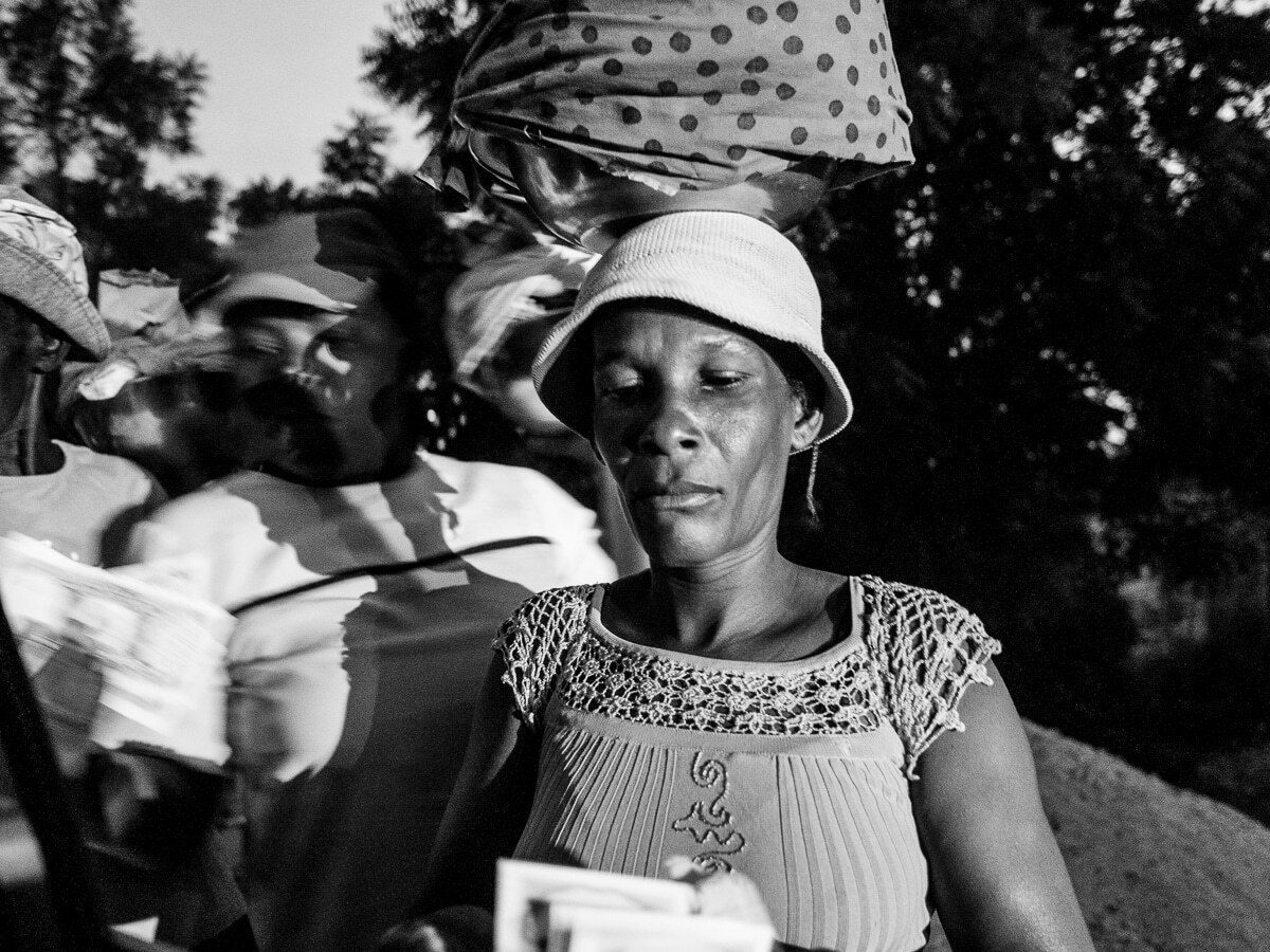 Street market scene with a woman in the foreground sharp and another woman behind her blurred by motion