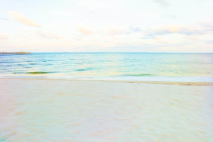 Soft pastel photo of an empty beach, turquoise sea and pale sky
