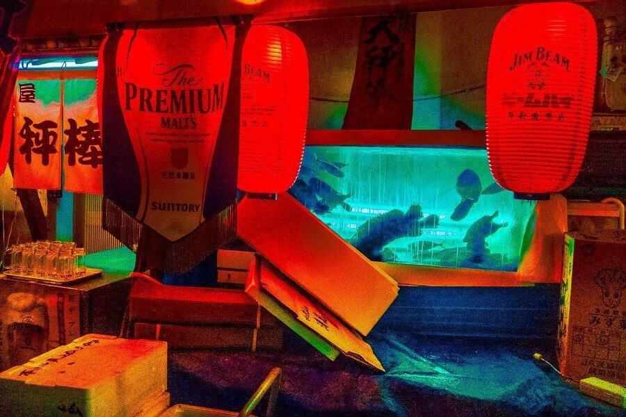 Colour night photo of glowing red paper lanterns and a blue lit display in a bar entrance